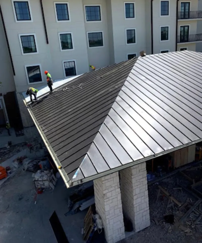 Crew installing standing seam metal roof panels on a commercial project in Radnor